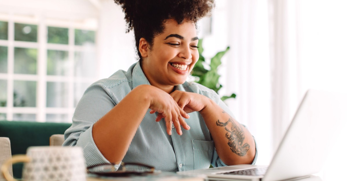 Lady in office with laptop, smiling