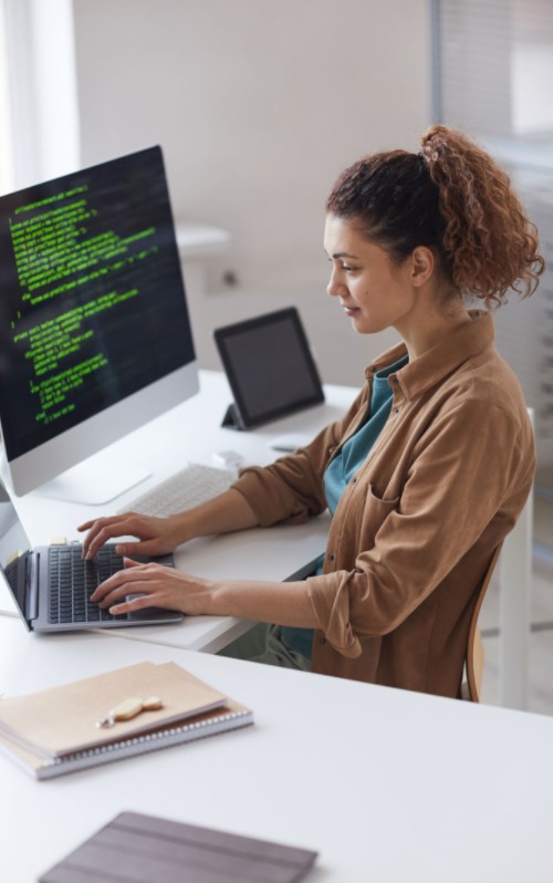 Cloud migration, lady sitting at computer coding