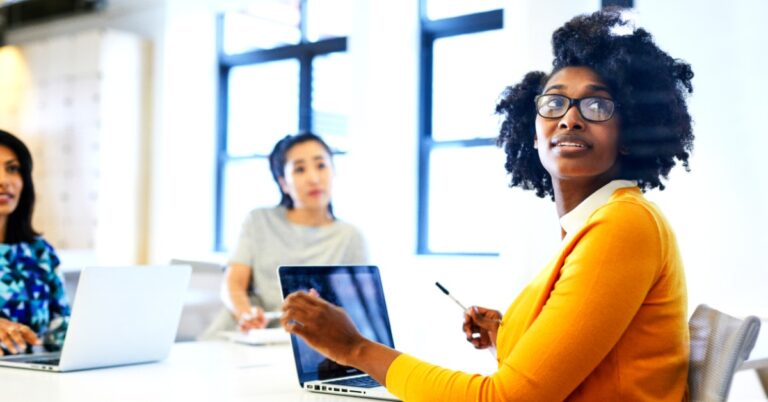 Women in yellow shirt at computer in office