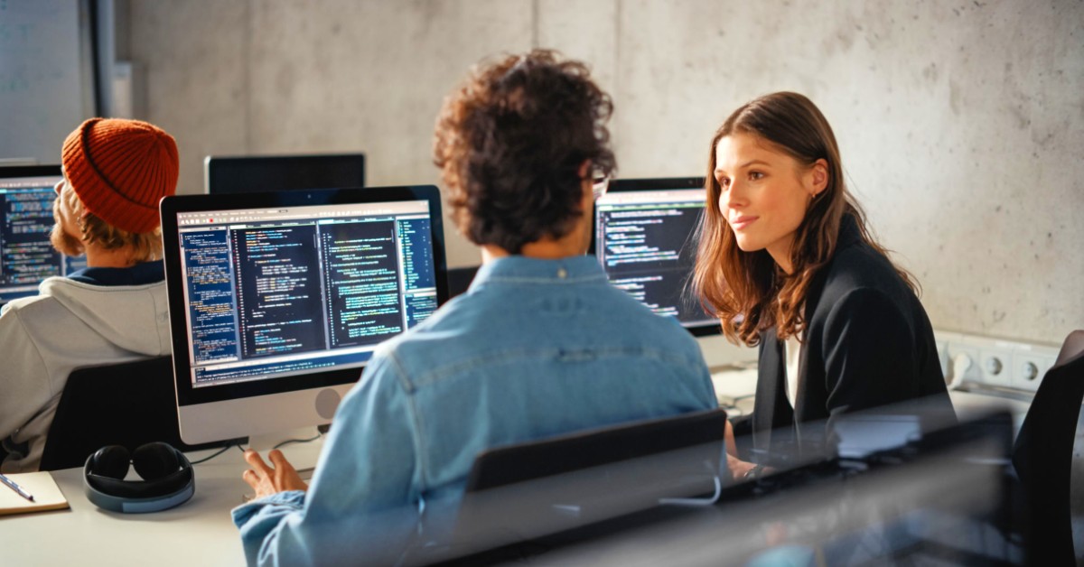 People discussing tech, and code at a computer in the office