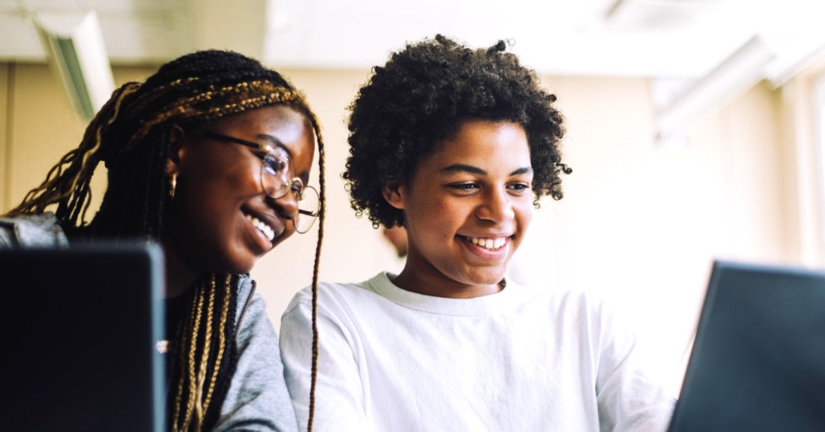 Two women coding in office with computer